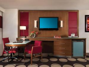 a hotel room with a desk with a tv and chairs at The Mirage in Las Vegas
