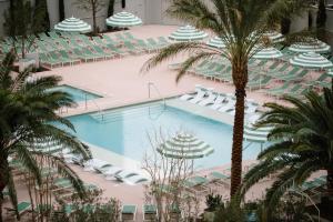 an overhead view of a hotel pool with chairs and palm trees at Park MGM Las Vegas in Las Vegas