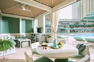 une terrasse avec une table, des chaises et une piscine dans l'établissement Park MGM Las Vegas, à Las Vegas