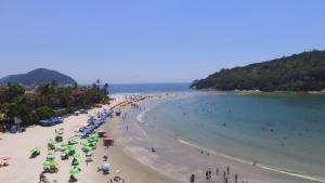 a beach with a bunch of people and umbrellas at Renovação Energia Positiva in Guarujá