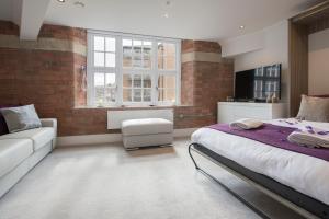 a bedroom with a bed and a couch and a window at ChocoLets - The Quality Suite in York