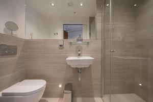 a bathroom with a toilet and a sink and a shower at ChocoLets - The Quality Suite in York