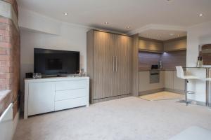 a living room with a kitchen with a tv and a counter at ChocoLets - The Quality Suite in York