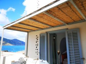 a pergola on a house with a view of the ocean at Ajamola in Favignana