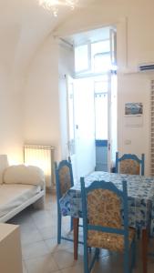 ヴィーコ・エクエンセにあるPenisola Apartmentのテーブル、椅子、ソファが備わる客室です。
