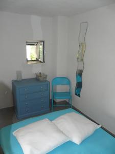 ein Schlafzimmer mit einem Bett, einer blauen Kommode und einem Spiegel in der Unterkunft Six-Bedroom House With Terrace Ionian Sea View in Neokhórion