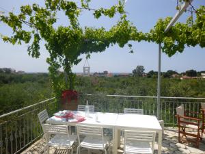 einen weißen Tisch und Stühle auf einer Terrasse mit Aussicht in der Unterkunft Six-Bedroom House With Terrace Ionian Sea View in Neokhórion