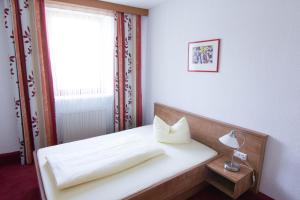 um quarto com uma cama branca e uma janela em Ratsstube Pegnitz em Pegnitz