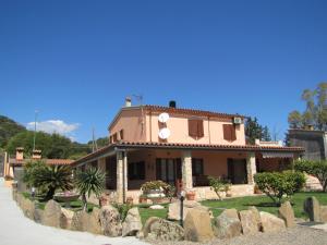 uma casa com um jardim em frente em B&B Monte Gruttas em Camisa