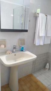 a white bathroom with a sink and towels at Green Hill House in Alykes