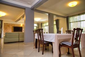 uma sala de jantar com uma mesa branca e cadeiras em Lakepoint Villa em Entebbe