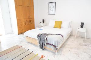 1 dormitorio con 1 cama en una habitación blanca en Concierge Downtown en Athens