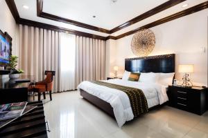 - une grande chambre avec un grand lit et un bureau dans l'établissement The Apo View Hotel, à Davao