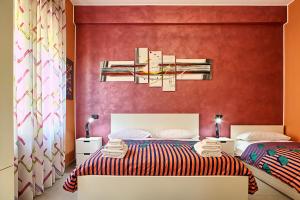 a bedroom with two beds and a red wall at La Collina dei Ciliegi in Salerno