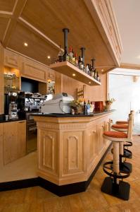 a kitchen with a large wooden island with stools at Hotel-Aparthotel San Bernardino in San Bernardino