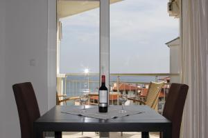 a table with a bottle of wine and two glasses at Galateya Sveti Vlas Bułgaria in Sveti Vlas