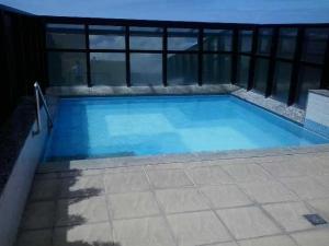 a large blue swimming pool on a balcony at NEO I - Ap. 627 in Maceió