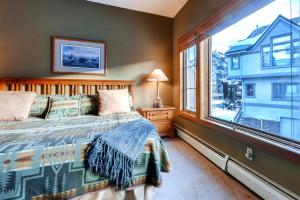 um quarto com uma cama e uma grande janela em One-Bedroom Elk Run Condo 23 em Copper Mountain