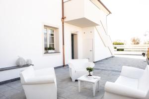 a white living room with white chairs and a table at La Locanda di Corrado in Cerreto Guidi