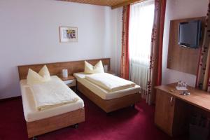 a hotel room with two beds and a television at Ratsstube Pegnitz in Pegnitz