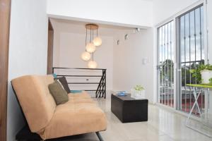 a living room with a couch and a table at Carlota Guest House in Cozumel