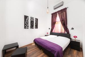 - une chambre avec un lit violet et une fenêtre dans l'établissement Karma Boutique Apartments, à Budapest