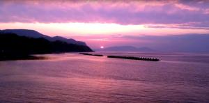 um pôr-do-sol sobre um corpo de água com um cais em Hotel Luna Coast (Adult Only) em Otaru