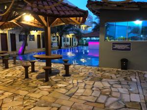 een patio met een tafel en banken voor een gebouw bij Hotel Concha do Mar in Salinópolis