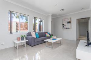 a living room with a couch and two tables at Ardross Short Stays in Perth