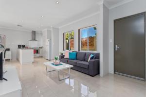 ein Wohnzimmer mit einem Sofa und einem Tisch in der Unterkunft Ardross Short Stays in Perth