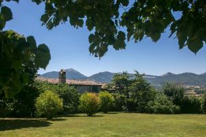un jardín con una casa y montañas en el fondo en La collina dei ciliegi, en Cagli