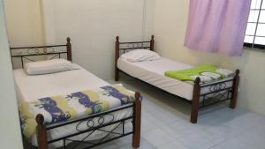 two twin beds in a room with a window at Desair Apartment By SCHT in Lumut