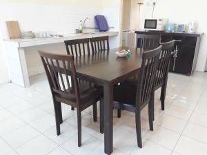 a wooden table and four chairs in a kitchen at Desair Apartment By SCHT in Lumut