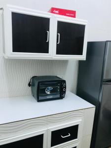 a microwave sitting on top of a counter next to a refrigerator at Galaxy VIP in Salalah