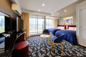a hotel room with two beds and a flat screen tv at Hotel Grandolce HAKATA in Fukuoka
