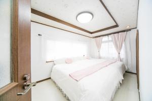 Una cama o camas en una habitación de Miraie Yokkaichi Kitahamacho