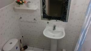 a bathroom with a sink and a toilet and a mirror at Apart Maxi in Arica