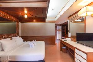 a bedroom with a white bed and a flat screen tv at Holiday Garden Hotel & Resort SHA EXTRA PLUS in Chiang Mai