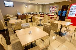 un restaurante con mesas y sillas de madera y personas de pie en la habitación en My Hotel @ Bukit Bintang, en Kuala Lumpur