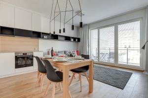 a dining room with a wooden table and chairs at TriApart Nova Grobla 3 in Gdańsk
