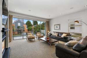 sala de estar con sofá, sillas y TV en City Sanctuary on Kilmore en Christchurch