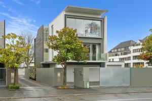 a large white building with a tree in front of it at City Sanctuary on Kilmore in Christchurch