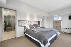 a bedroom with a large bed and a large window at City Sanctuary on Kilmore in Christchurch