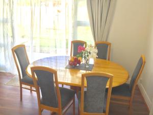 a dining room table with chairs and a vase of flowers on it at G- HOUSE (CH-CH) in Christchurch
