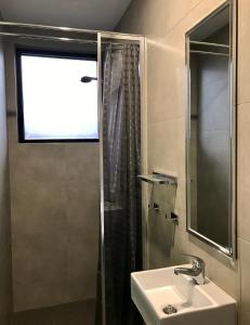 a bathroom with a sink and a shower at Breeze Lodge in Brisbane