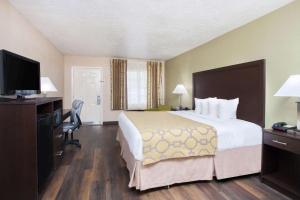 A bed or beds in a room at Baymont by Wyndham Lake City