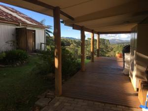a wooden porch with a view of the mountains at Mirradong Cottage in Berambing