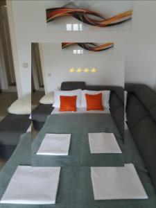 a bedroom with a bed with orange pillows at LANELU apartman in Rogoznica
