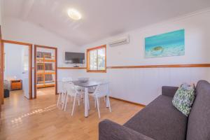 uma sala de estar com um sofá, uma mesa e cadeiras em NRMA Blue Dolphin Yamba Holiday Resort em Yamba