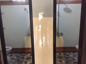 a glass shower in a bathroom with a toilet at Hoang Nga Garden Guesthouse in Mui Ne